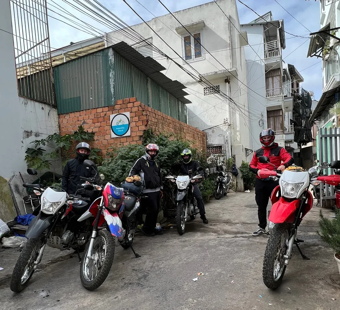 Riders with Honda XR150 motorbikes in the alley outside the Motorbike Dalat shop